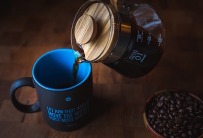 透明玻璃茶壶用蓝色陶瓷杯倒茶